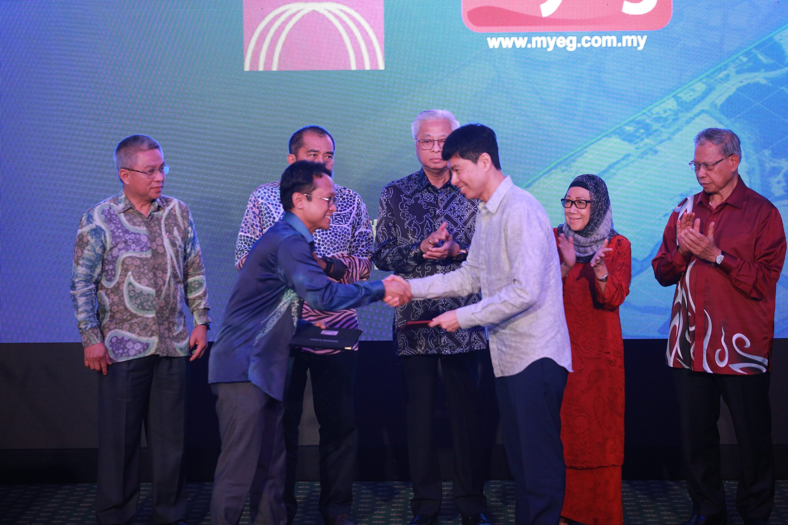 Dr. Iskandar Samad CEO of MIMOS Global front left and Mr. Wong Thean Soon Group Managing Director of MYEG Services Bhd front right exchanging the MOU under the witness of YAB Dato Sri Ismai scaled